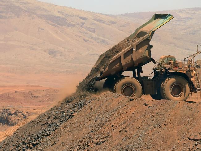 An autonomous haul truck dumps a load of rock in the mine pit at Rio Tinto Group's Gudai-Darri iron ore mine in the Pilbara region of Western Australia, Australia, on Thursday, Oct. 19, 2023. Rio Tinto is preparing for trials of battery-powered locomotives in Australia, where it uses giant autonomous trains — the world’s largest and longest robots — to transport iron ore across the vast Outback. Photographer: Carla Gottgens/Bloomberg