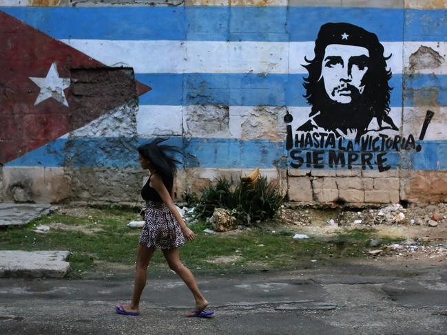 HAVANA, CUBA - JANUARY 24:  A young woman walks past a mural dipicting Cuban revolutionary leader Che Guevarra in the Jesus Maria neighborhood January 24, 2015 in Havana, Cuba. Diplomats from the United States and Cuba held historic talks this week that could restore diplomatic ties and mark the end of more than 50 years of of Cold War-era hostility between the two countries.  (Photo by Chip Somodevilla/Getty Images)