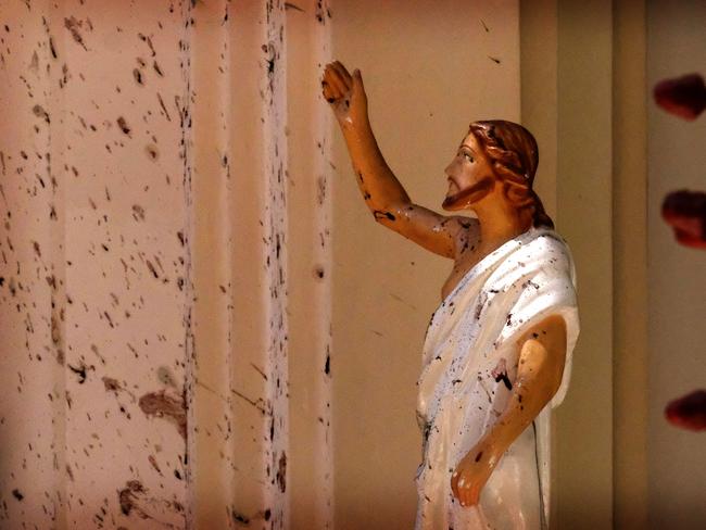 Blood stains are seen on the wall and on a Jesus Christ statue at the St. Sebastian's Church after blast in Negombo, north of Colombo. Picture: AP