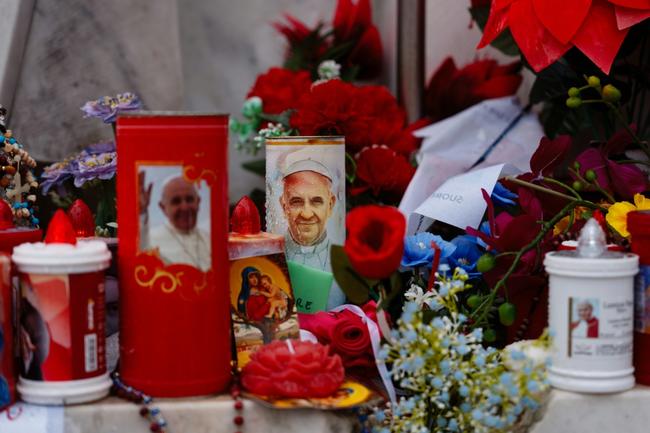 Candles and flowers laid at the statue of John Paul II