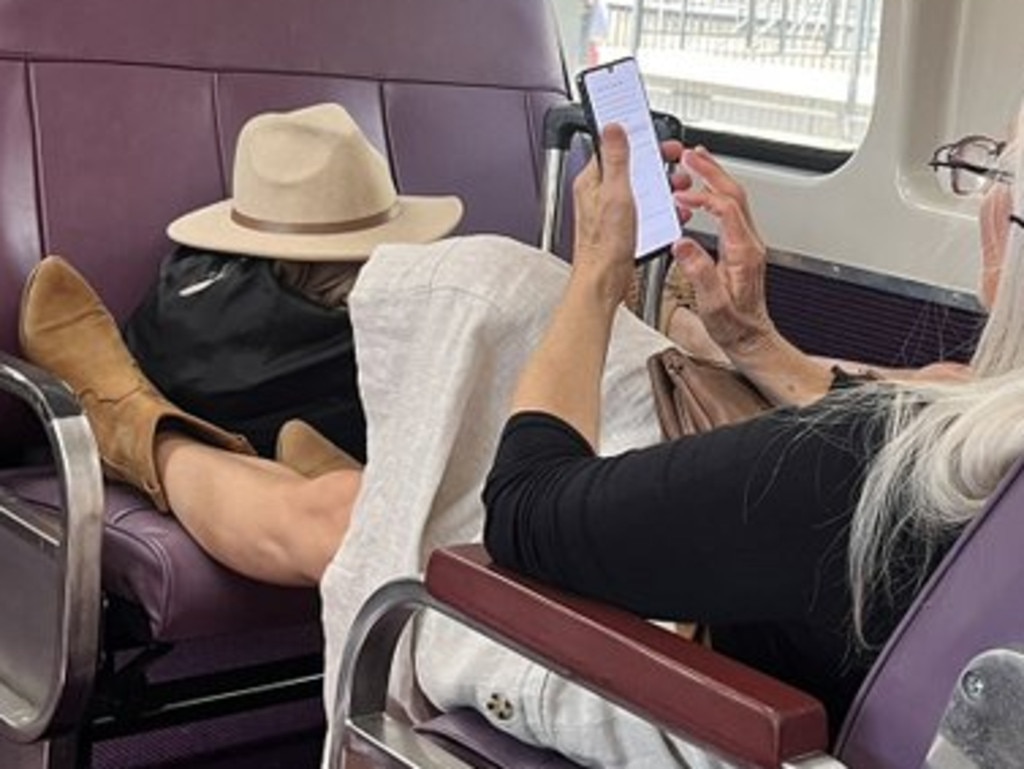 Two people refused to give up their seat on a NSW train, instead putting their feet up. Source: X