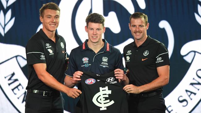 Sam Walsh receives his guernsey from Carlton captains Patrick Cripps and Sam Docherty.