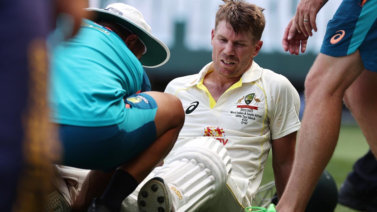 David Warner is helped from the ground after retiring hurt after reaching 200 . Picture by Michael Klein