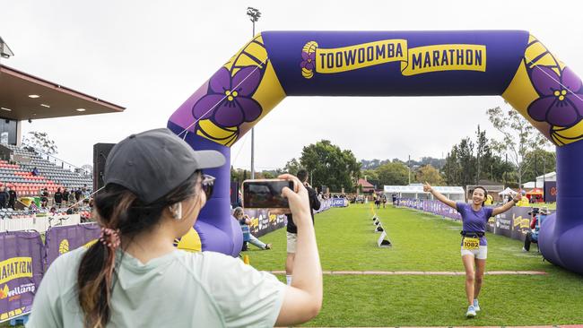 Sai Lu photographs her friend Summer Meng as she finishes the half marathon of the Toowoomba Marathon event, Sunday, May 5, 2024. Picture: Kevin Farmer