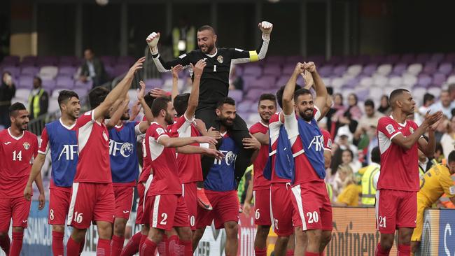 Jordan players celebrate their win over Australia. The result has worked in the Socceroos’ favour.