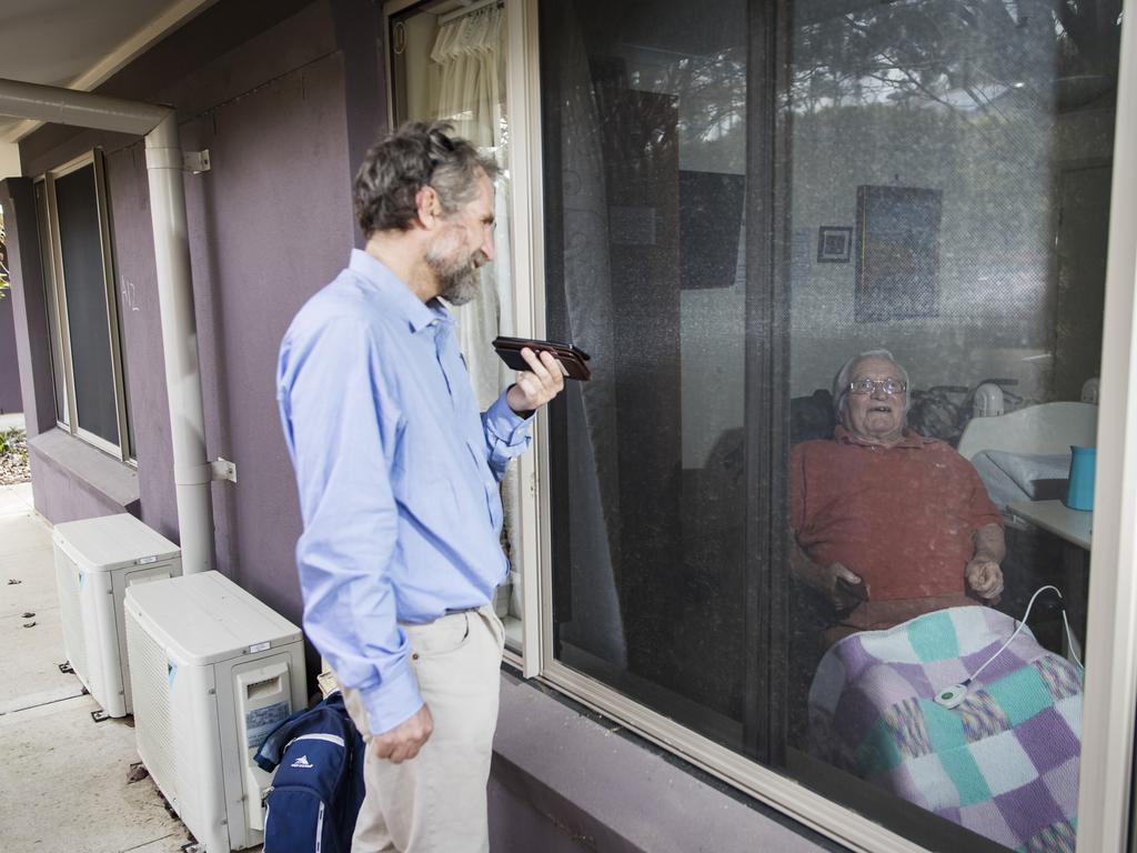 Matthew Fowler visits his father Lionel, 88, through the window of his Newmarch House room. Picture: Dylan Robinson