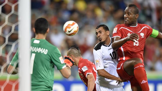 Younus Mahmood of Iraq (C) and Abdallatif Albahdari of Palestine (R) fight for the ball.