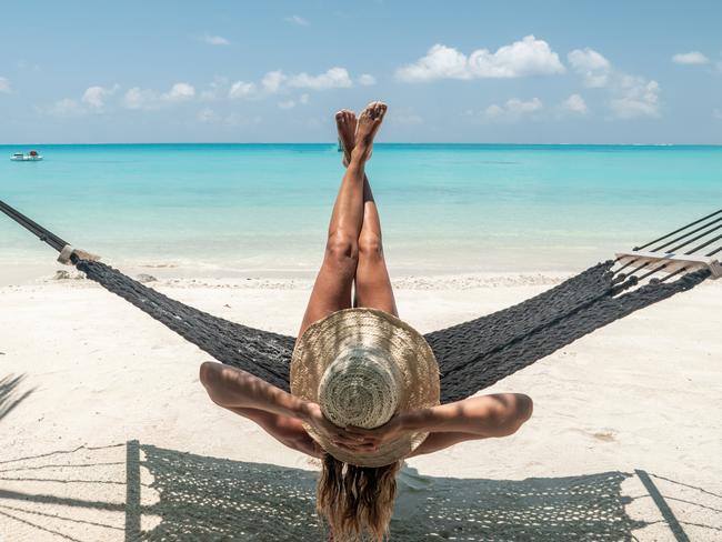 Woman lying in a hammock on a white sand beach relaxing and sunbathing by the sea in the MaldivesPhoto - istockEscape 6 Nov 2022ed's letter