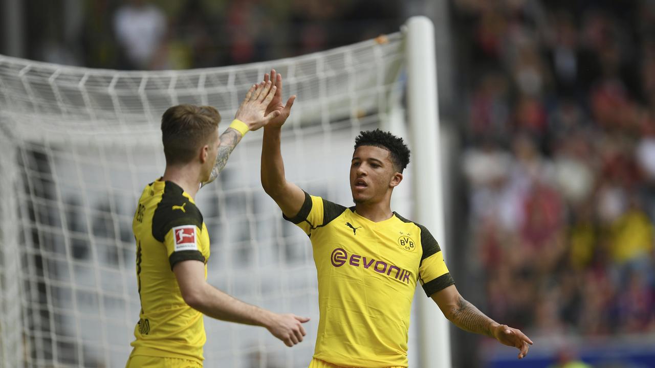 Dortmund's Jadon Sancho celebrates with Marco Reus)
