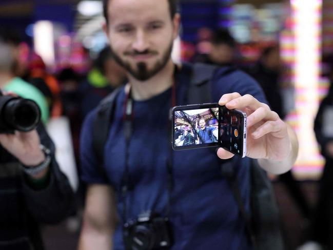 A visitor holds a new mobile phone on Oppo stand at the Mobile World Congress (MWC), the telecom industry's biggest annual gathering, in Barcelona on February 27, 2023. (Photo by Thomas COEX / AFP)