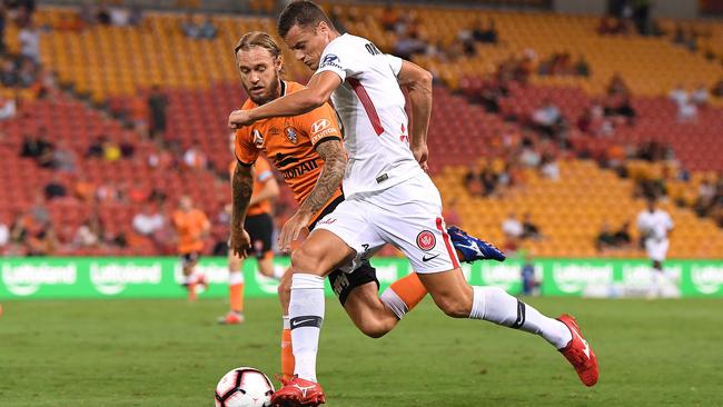 Wanderers striker Oriol Riera runs at Roar’s Jacob Pepper at Suncorp Stadium. Picture: AAP