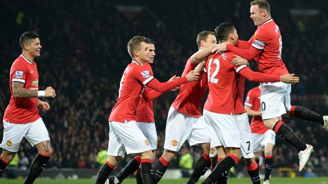 Manchester United's English defender Chris Smalling (2nd R) celebrates with teammates after scoring the opening goal of the English Premier League football match between Manchester United and Burnley at Old Trafford in Manchester, north west England, on February 11, 2015. AFP PHOTO / OLI SCARFF RESTRICTED TO EDITORIAL USE. No use with unauthorized audio, video, data, fixture lists, club/league logos or “live” services. Online in-match use limited to 45 images, no video emulation. No use in betting, games or single club/league/player publications.