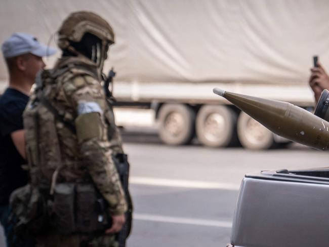 Two grenade launchers in a car as local residents pose for a photograph with a member of the Wagner group. Picture: Roman Romokhov