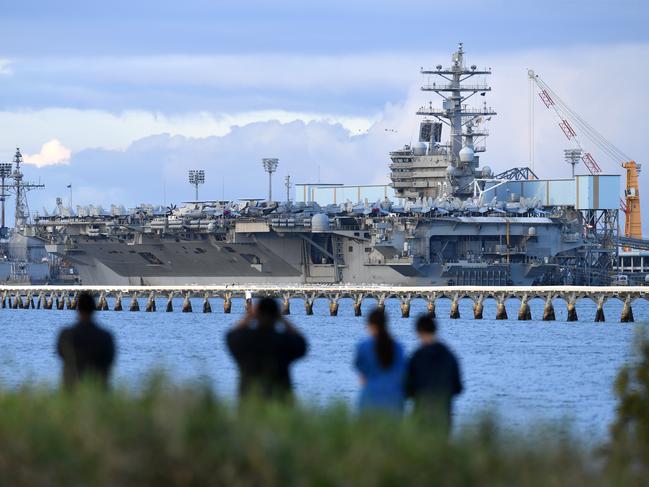 Locals watch on as the aircraft carrier USS Ronald Reagan is docked at the Port of Brisbane this week. Picture: Dan Peled/AAP