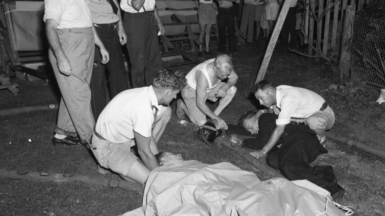 A fireman and a civilian overcome by smoke during a blaze at the Sherwood Picture Theatre in 1951 are looked after by patrons. Picture: Al Pascoe