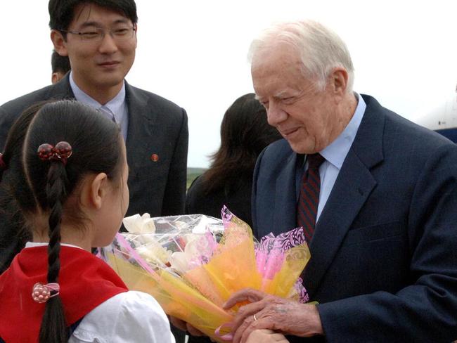 Former US president Jimmy Carter receives a bouquet of flowers from a girl upon arrival at Pyongyang airport during a 2010 mission to win the release of an American serving eight years of hard labour in the communist state. Picture: AFP/KCNA/KNS