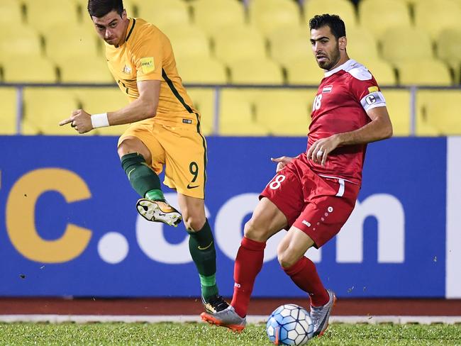 Australia's Tomi Juric (L) and Syria's Zaher Almedani (R) compete for the ball during the 2018 World Cup qualifying football match between Syria and Australia at the Hang Jebat Stadium in Malacca on October 5, 2017.  / AFP PHOTO / MOHD RASFAN