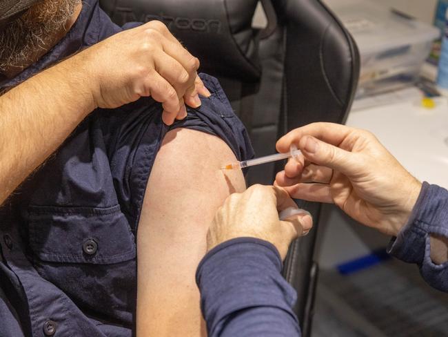 A pharmacist administers the injection of a Covid-19 vaccination booster-shot to a customer in Melbourne. Picture: Asanka Ratnayake/Getty Images