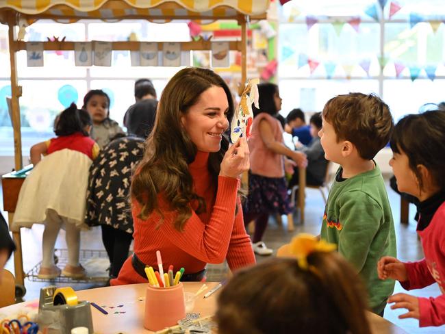 Britain's Catherine, Princess of Wales holds a mask to her face as she interacts with children during her visit to Foxcubs Nursery. Picture: AFP