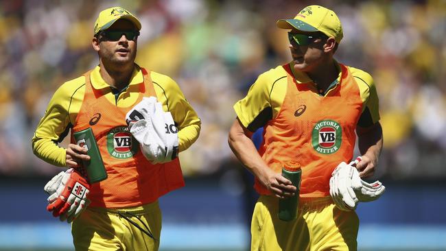 Michael Clarke and James Faulkner run the drinks during Australia’s opening World Cup match against England at the MCG last Saturday.
