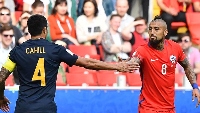 Cahill slaps skin with Chile midfielder Arturo Vidal.