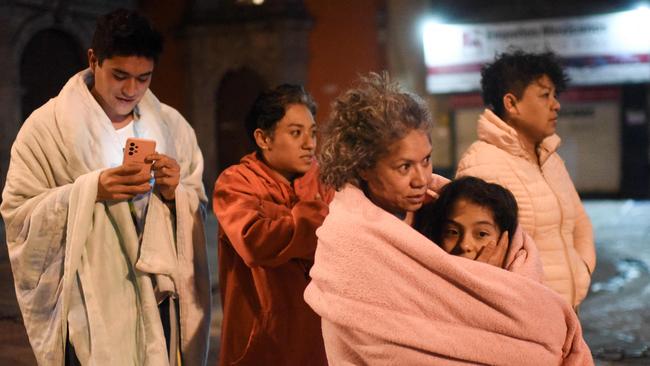 Residents stand in a street after a 6.8-magnitude earthquake in Mexico City on September 22, 2022. (Photo by Pedro PARDO / AFP)