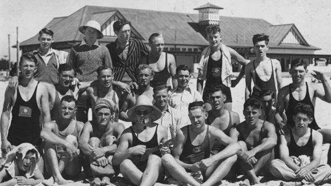 Three days before the attack, Kirra members pose for a photograph — second row extreme right kneeling with hand raised is Joe Doniger, Second row extreme left kneeling in neck to knee swimsuit with surf reel on it is Jack Brinkley Front row sitting third from right in cap is Norm (Blue) Girvan next to the lifesaver playing the Banjo.