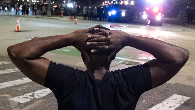 A protester holds his hands on his head in front of a formation of Detroit riot police. Picture: Seth Herald/AFP