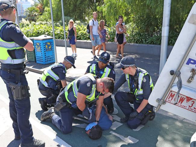 Officers surround the man as he becomes increasingly aggressive. Picture: Alex Coppel.