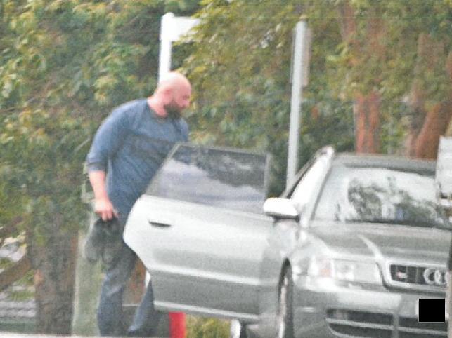 Alexandre Dubios holding a pair of work boots, looking inside the rear driver’s door of vehicle parked on Brodie Street, Yagoona. Picture: ICAC