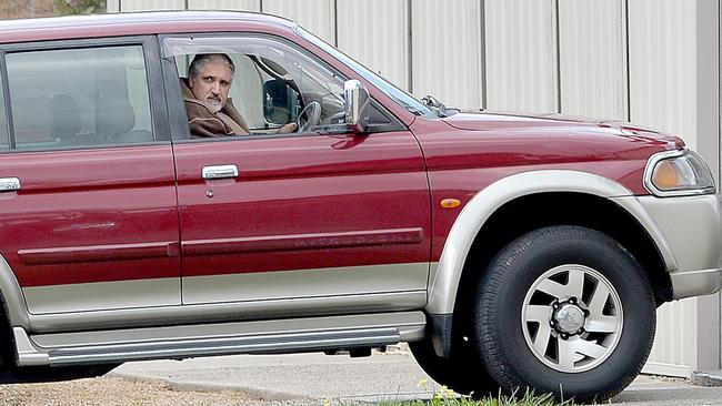 Paulino in his car outside his former home.