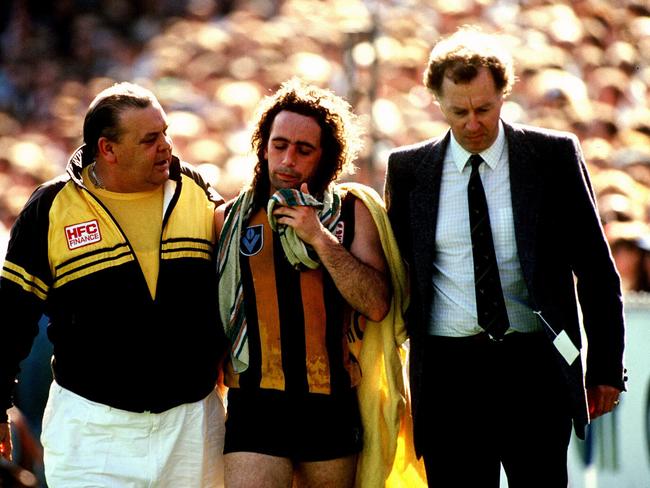 A concussed John Platten being taken back to the rooms during the 1989 Grand Final against Geelong.