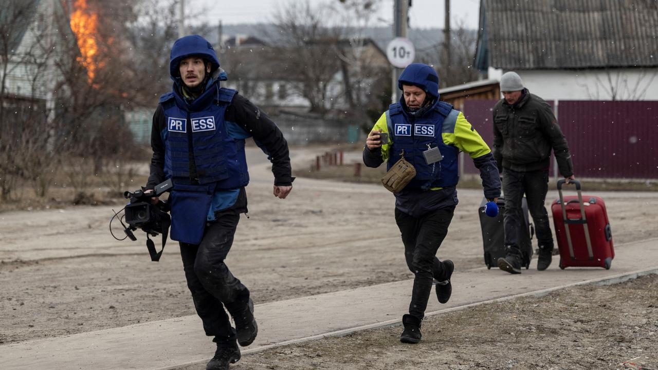 Journalists run for cover after heavy shelling on the only escape route used by locals, while Russian troops advance towards the capital, in Irpin, near Kyiv, Ukraine March 6, 2022. Picture: Reuters/Carlos Barria.