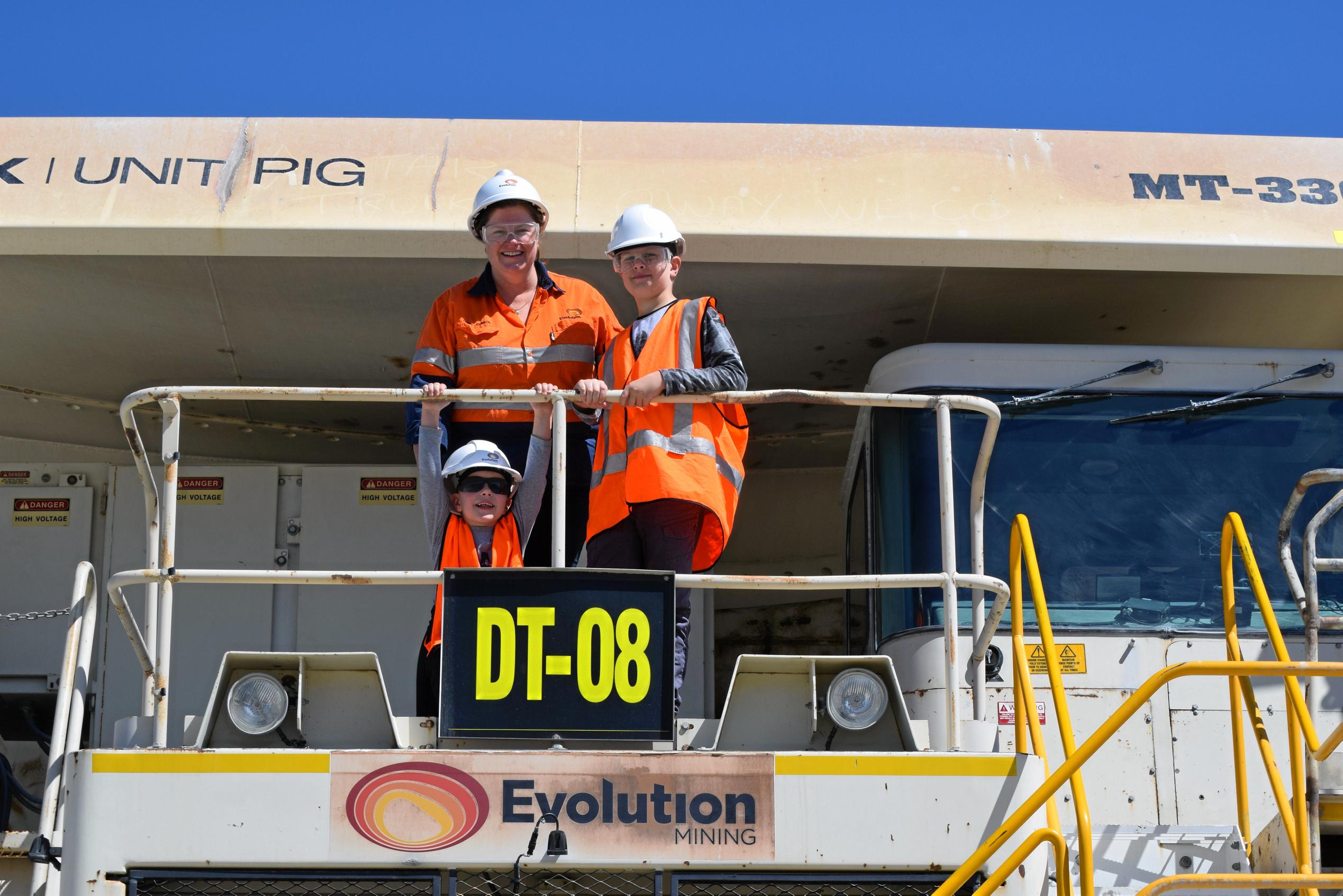 Xavier, Coby and Penny Johnson pose for a photo on one of the dump trucks. Picture: Marissa Newman