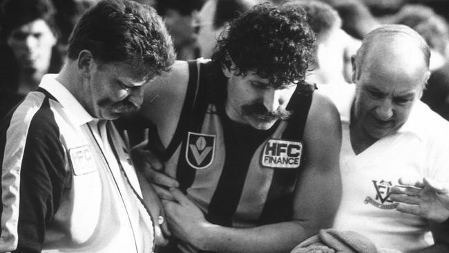 30/09/1989 SPORT: Robert DiPierdomenico is helped from the field by trainer Bob Holland (R) after puncturing a lung. 1989 Grand Final. Hawthorn v Geelong. MCG. Picture: Peter Ward.