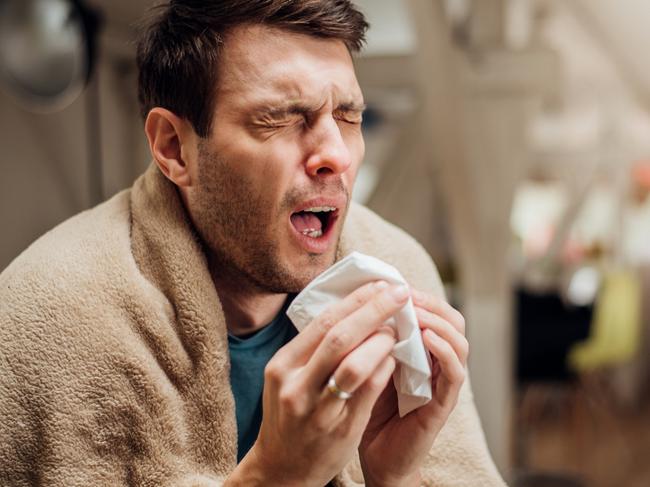 Sick young man coughing and sneezing