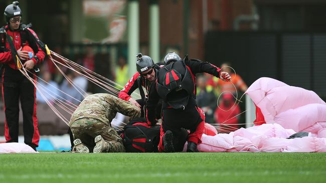 The paratrooper from the Australian Army Red Berets being attended to after crash landing on the SCG. Picture: Phil Hillyard