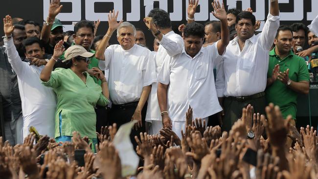 Sri Lanka's sacked prime minister Ranil Wickremesinghe, third from left, waves to his supporters in Colombo last night.