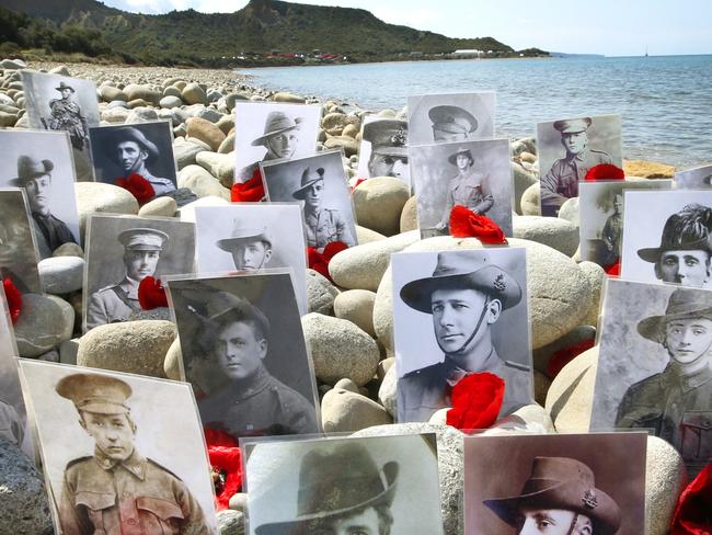 ANZAC 100th Gallipoli ... ANZAC Diggers’ photos lined up on North Beach with Ari Burnu in the background. Picture: David Caird.