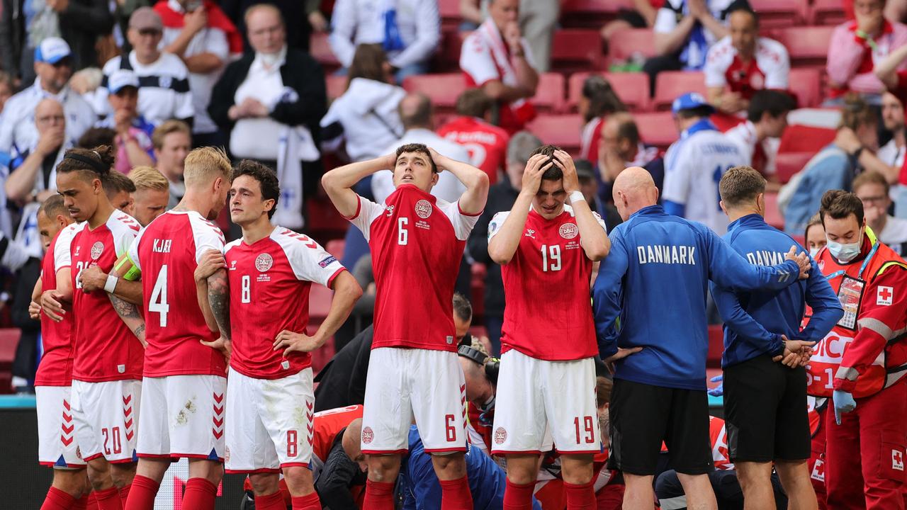 Denmark players react as Eriksen is treated by paramedics.