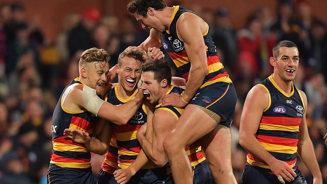 Tom Doedee is swamped by his teammates after kicking his first AFL goal.