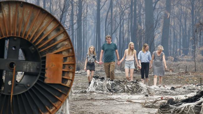 Mark and Cate Tregellas inspect their scorched property with daughters Jessica, Emily and Sarah. Picture: David Caird