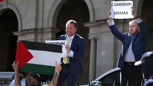 One protester reached over the fence and grabbed the sign from Nick Dametto, scrunching it up and throwing it on the ground. Picture: Dan Peled / NCA NewsWire