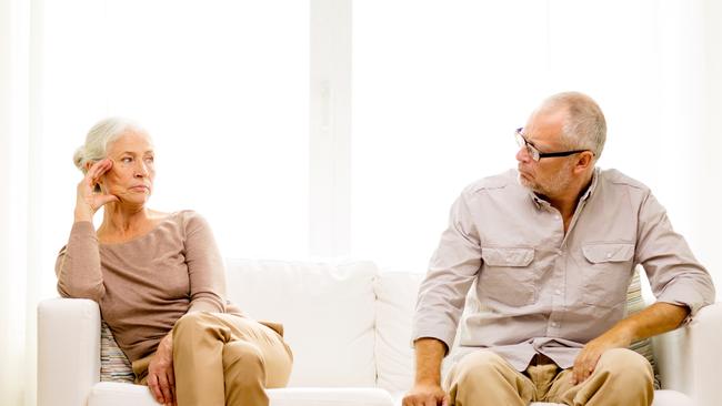 family, relations, age and people concept - senior couple sitting on sofa at home