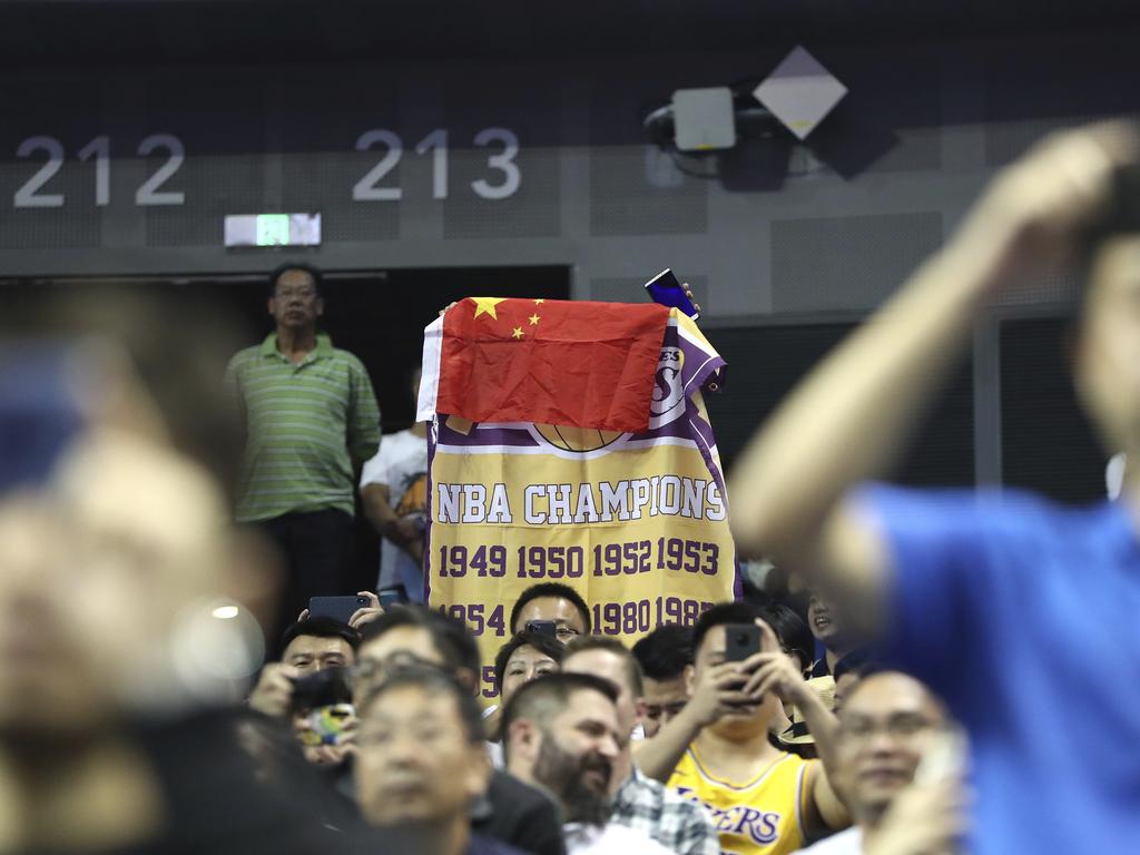 A fan drapes a China flag over an NBA banner.