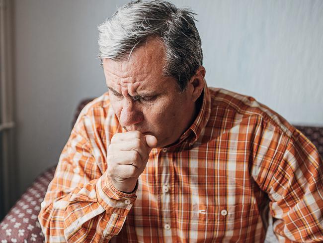 One man, worried senior man, sitting alone at his home. He has a pain in his knee.