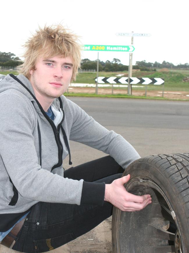 Mathew Roberts with one of the two tyres and rims that were ruined when he hit a pothole on the Henty Highway at Hamilton in 2010.