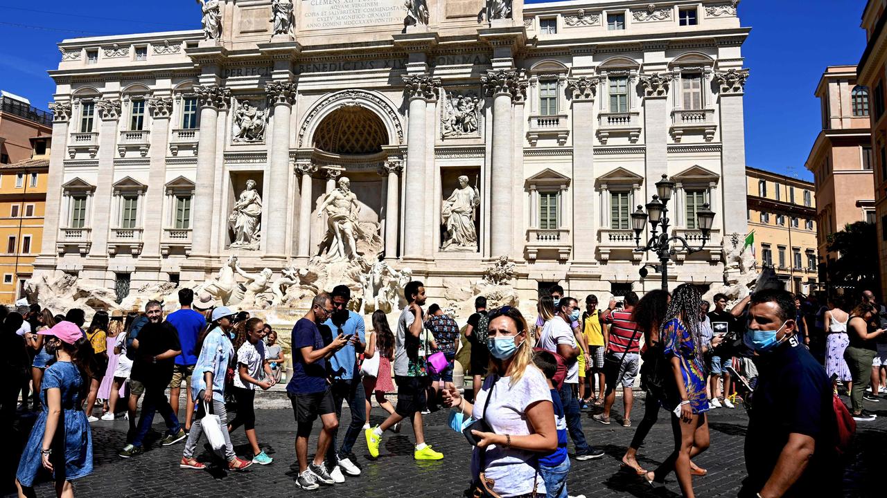 Tourists walk by the Trevi fountain in downtown Rome on August 19, 2020 during the COVID-19 pandemic. (Photo by Vincenzo PINTO / AFP)