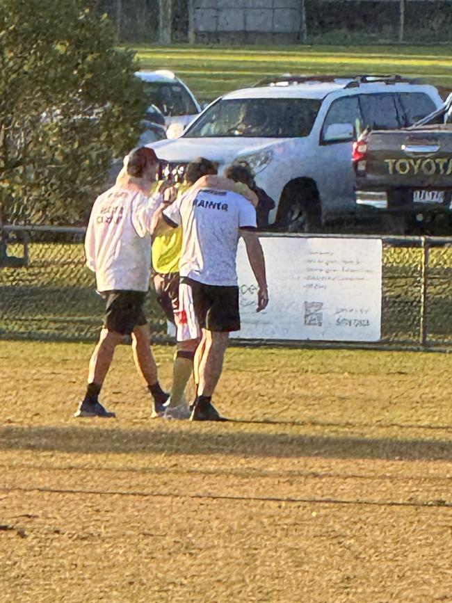 A field umpire suffers a leg injury and is helped off.