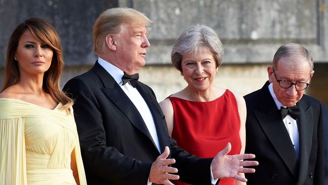 (L-R) US President Donald Trump, Britain's Prime Minister Theresa May, US First Lady Melania Trump and Philip May stand on the steps in the Great Court to watch the bands of the Scots, Irish and Welsh Guards perform a ceremonial welcome as they arrive for a black-tie dinner with business leaders at Blenheim Palace, west of London, on July 12, 2018, on the first day of President Trump's visit to the UK.  The four-day trip, which will include talks with Prime Minister Theresa May, tea with Queen Elizabeth II and a private weekend in Scotland, is set to be greeted by a leftist-organised mass protest in London on Friday. / AFP PHOTO / POOL AND AFP PHOTO / Niklas HALLE'N